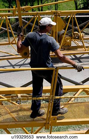 Stock Image - aerial view of workman holding pinion to attach to crane boom on ground. Fotosearch