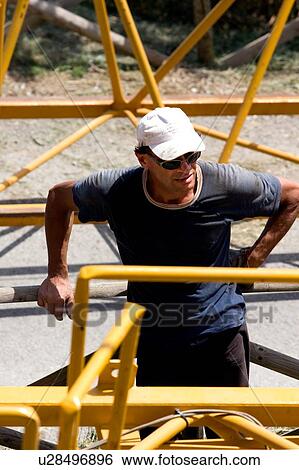 Stock Photograph - aerial view of workman standing on crane boom on ground, closeup. Fotosearch