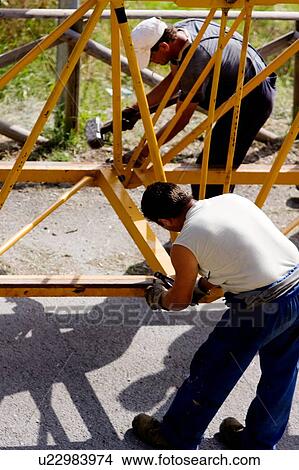 aerial view of workmen assembling crane boom to be lifted from ground View Large Photo Image Picture - aerial view of workmen assembling crane boom to be lifted from ground . Fotosearch