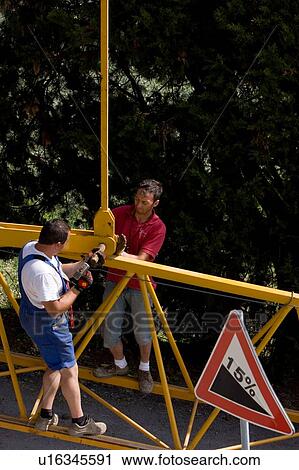 Aerial view of workmen attaching crane pinion to boom, on ground, using hammer View Large Photo Image Stock Image - Aerial view of workmen attaching crane pinion to boom, on ground, using hammer. Fotosearch