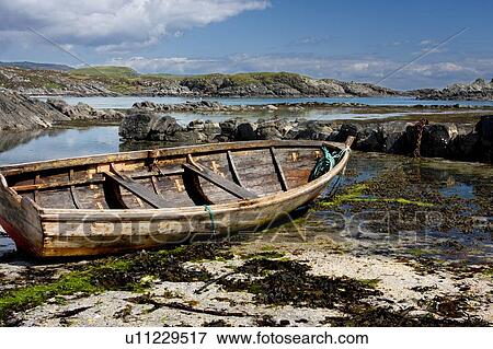 Stock Photo - Arolainish Bay, Isle of Mull, Scotland, boat beached on shore at low tide, with rope covered in bright green sea weed. Fotosearch