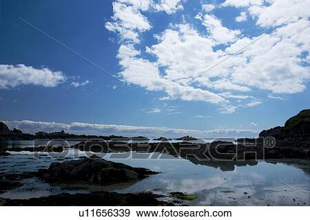 Arolainish Bay, Isle of Mull, Scotland with tidal pools at beach reflecting blue sky and white cloud formations, rocks silhouetted View Large Photo Image Stock Photo - Arolainish Bay, Isle of Mull, Scotland with tidal pools at beach reflecting blue sky and white cloud formations, rocks silhouetted. Fotosearch