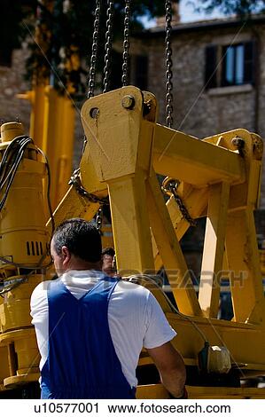 Stock Image - assembly of rotation platform of crane with workman in foreground. Fotosearch