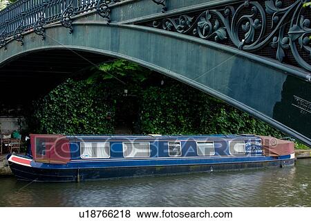 Stock Photo - Barge moored near Camden Lock Canal with old iron bridge above. Fotosearch