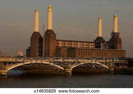 Stock Photo - Battersea power stationin evening light with railway bridge across River Thames in foreground. Fotosearch