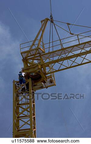 Stock Photo - cabin and boom being atached to crane tower by workmen . Fotosearch