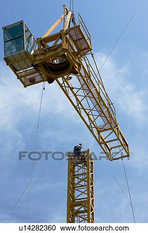 cabin and crane boom being swung through air with workmen on tower to position assembly View Large Photo Image Stock Image - cabin and crane boom being swung through air with workmen on tower to position assembly . Fotosearch