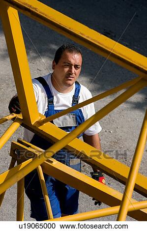 close up of workman standing beside part of crane boom on ground, aerial view View Large Photo Image Stock Image - close up of workman standing beside part of crane boom on ground, aerial view. Fotosearch