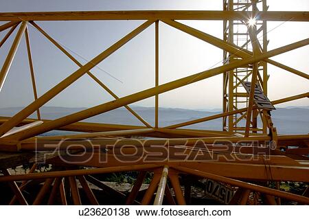 Stock Photo - crane boom lying on ground with early morning mist of italian landscape in background. Fotosearch