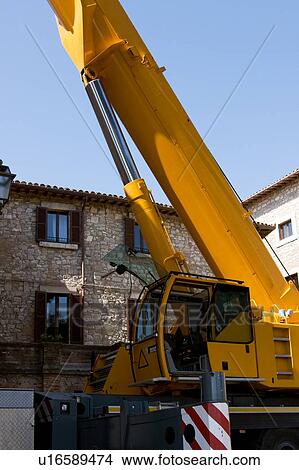 Picture - Crane cabin and base of tower, in Italian piazza with stone buildings in background. Fotosearch