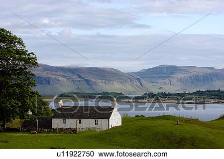 Stock Image - farm cottage near Loch Tuath, west Isle of Mull, with mountains in background. Fotosearch