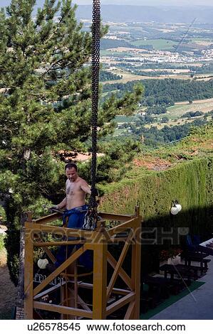 Man assembling crane tower, with connectors and chains, Italian landscape in background View Large Photo Image Stock Photography - Man assembling crane tower, with connectors and chains, Italian landscape in background. Fotosearch
