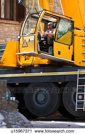 Stock Image - man operating crane in cabin. Fotosearch