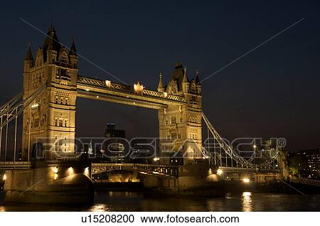 Stock Image - Tower Bridge at night as seen from south bank of Thames. Fotosearch