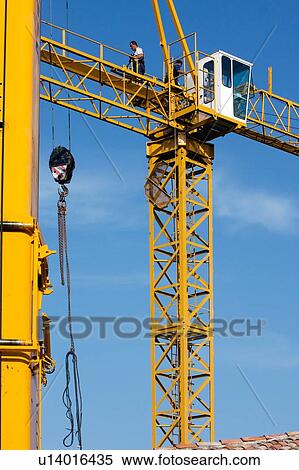 two cranes during assembly, with tiled Italian rooftop and blue sky View Large Photo Image Stock Photography - two cranes during assembly, with tiled Italian rooftop and blue sky . Fotosearch