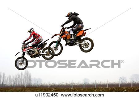 Two motocross riders flying through air, side view View Large Photo Image Stock Image - Two motocross riders flying through air, side view. Fotosearch