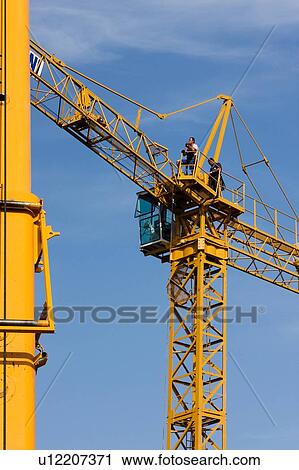 view of crane lifting crane boom into position for assembly with workman climbing along boom View Large Photo Image Stock Image - view of crane lifting crane boom into position for assembly with workman climbing along boom. Fotosearch