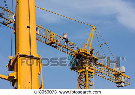 view of crane lifting crane boom into position for assembly with workman climbing along boom View Large Photo Image Stock Image - view of crane lifting crane boom into position for assembly with workman climbing along boom . Fotosearch