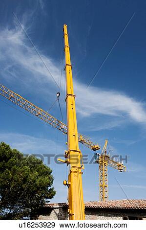 Stock Photo - view of crane lifting crane boom into position for assembly . Fotosearch