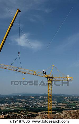 view of crane lifting crane boom into position for assembly with workman climbing along boom View Large Photo Image Stock Photography - view of crane lifting crane boom into position for assembly with workman climbing along boom. Fotosearch