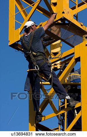 workman attaching new piece of crane tower swung in overhead View Large Photo Image Stock Image - workman attaching new piece of crane tower swung in overhead . Fotosearch