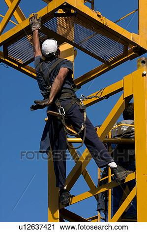 workman grabbing new piece of crane tower being swung in overhead View Large Photo Image Stock Image - workman grabbing new piece of crane tower being swung in overhead . Fotosearch