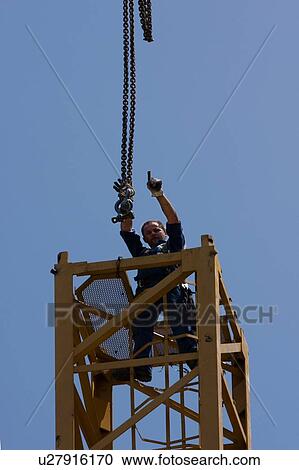 workman signalling to co- workers to remove hooks from crane tower during assembly View Large Photo Image Stock Image - workman signalling to co- workers to remove hooks from crane tower during assembly. Fotosearch