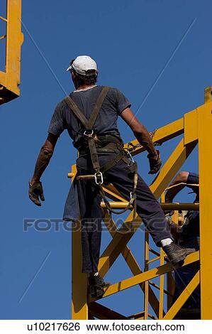 workman waiting to attach new piece of crane tower being swung in overhead View Large Photo Image Stock Photograph - workman waiting to attach new piece of crane tower being swung in overhead. Fotosearch