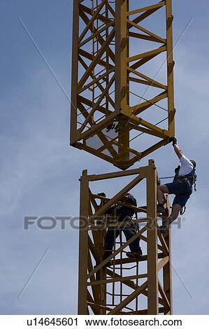 workmen guiding part of crane tower swinging through air for assembly View Large Photo Image Stock Image - workmen guiding part of crane tower swinging through air for assembly. Fotosearch
