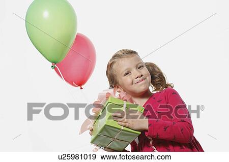 Young girl holding present & balloons View Large Photo Image Stock Photo - Young girl holding present & balloons. Fotosearch