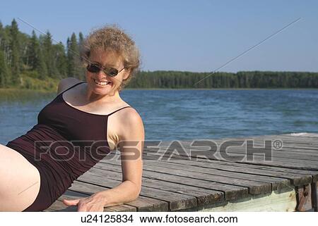 Picture - 45 year old woman on dock Katherine L.; Canada, Manitoba, Riding Mountain National Park. Fotosearch