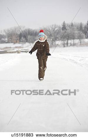 Stock Image - 9 year old girl skating on Red River, Winnipeg, Canada. Fotosearch