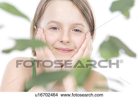 Picture - 9 year old girl with the green leafs around her. Fotosearch