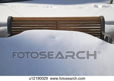 A park bench covered in snow View Large Photo Image Stock Photo - A park bench covered in snow. Fotosearch
