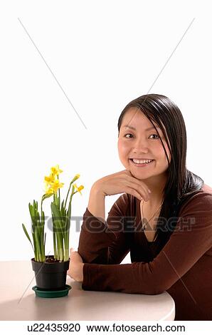 Stock Image - Asian Young girl w/Flower, Regina, Saskatchewan. Fotosearch