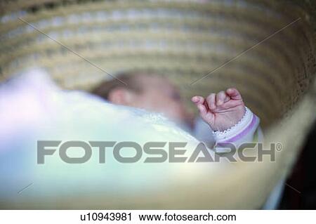 Stock Image - Baby sleeping in basket, Saskatchewan. Fotosearch