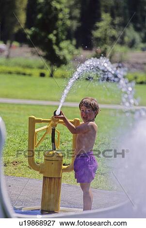 Boy, 3, plays with water sprayer at water park, Pemberton, B. C. View Large Photo Image Stock Photo - Boy, 3, plays with water sprayer at water park, Pemberton, B. C.. Fotosearch