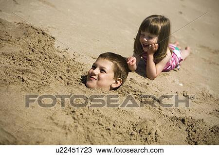 Boy, (7) buried up to his neck in the sand, with girl (4) beside, Grand Beach Provincial Park, Manitoba, Canada View Large Photo Image Stock Image - Boy, (7) buried up to his neck in the sand, with girl (4) beside, Grand Beach Provincial Park, Manitoba, Canada. Fotosearch