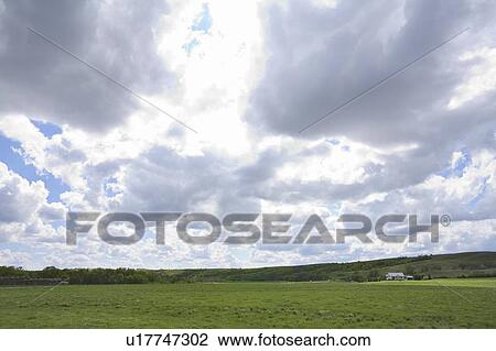 Stock Image - Dramatic clouds of green field, Lumsden, Saskatchewan, Canada. Fotosearch