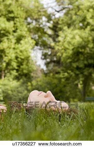 Face of woman lying in the grass, Munson Park, Winnipeg, Canada View Large Photo Image Stock Photo - Face of woman lying in the grass, Munson Park, Winnipeg, Canada. Fotosearch