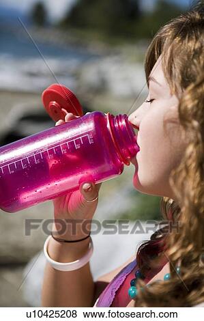 Female, 17, drinking from water bottle while at the beach, English Bay, Vancouver, BC View Large Photo Image Stock Photo - Female, 17, drinking from water bottle while at the beach, English Bay, Vancouver, BC. Fotosearch