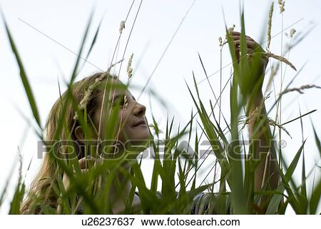 Girl in long grass looks at seed head, Winnipeg, Canada View Large Photo Image Stock Photo - Girl in long grass looks at seed head, Winnipeg, Canada. Fotosearch