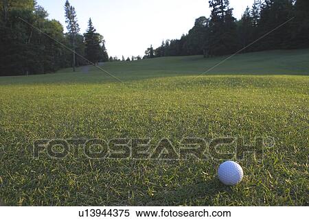 Stock Photography - Golf ball on organic golf course; Canada, Manitoba, Riding Mountain National Park. Fotosearch