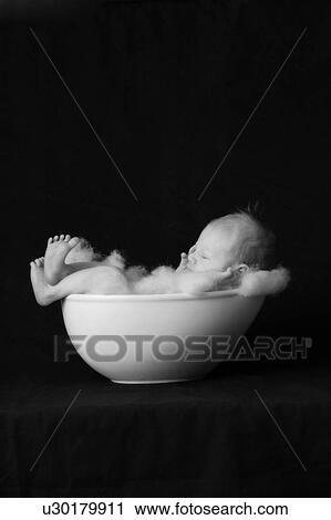 Infant child in bowl, on black background View Large Photo Image Stock Image - Infant child in bowl, on black background. Fotosearch
