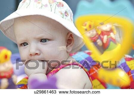 Infant trying to swallow fist, wearing sun hat, Echo Lake, Saskatchewan, Canada View Large Photo Image Stock Image - Infant trying to swallow fist, wearing sun hat, Echo Lake, Saskatchewan, Canada. Fotosearch