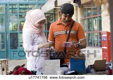Stock Photograph - Islamic young couple at an outdoor market, Winnipeg, Canada. Fotosearch