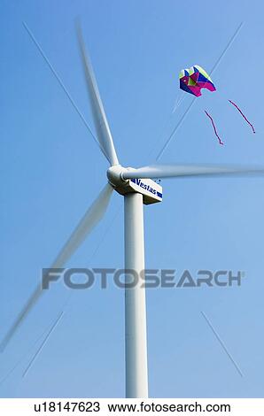 Stock Image - Kite flying near wind turbine.. Fotosearch