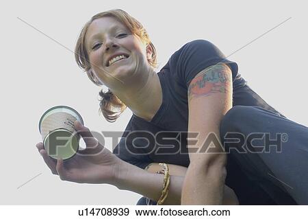 Stock Photo - Low angle portrait of woman holding corn-based compostable coffee cup. Fotosearch