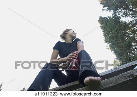 Stock Image - Low angle portrait of woman with re-useable water bottle. Fotosearch