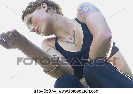 Low angle portrait of woman with tattoos View Large Photo Image Picture - Low angle portrait of woman with tattoos. Fotosearch
